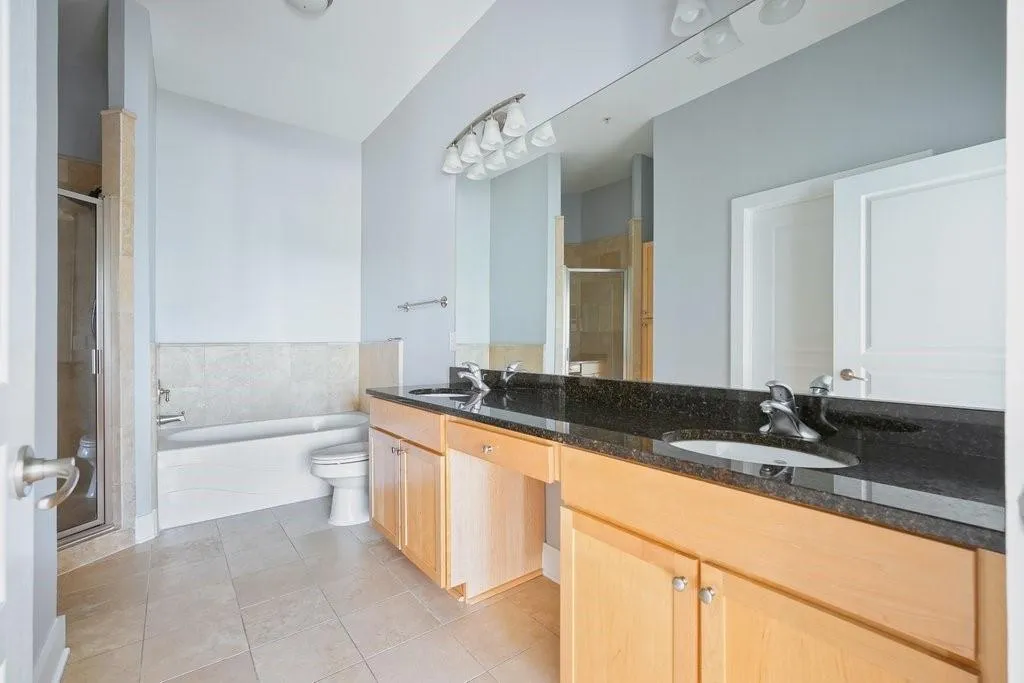 Full bathroom featuring shower with separate bathtub, tile floors, dual sinks, and large vanity Full bathroom featuring shower with separate bathtub, tile floors, dual sinks, and large vanity
