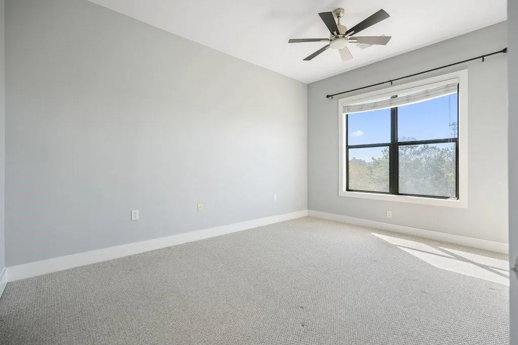 Carpeted empty room featuring ceiling fan Carpeted empty room featuring ceiling fan