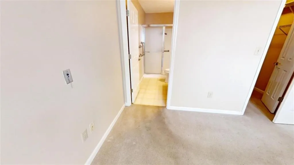 Corridor with baseboards and light colored carpet
