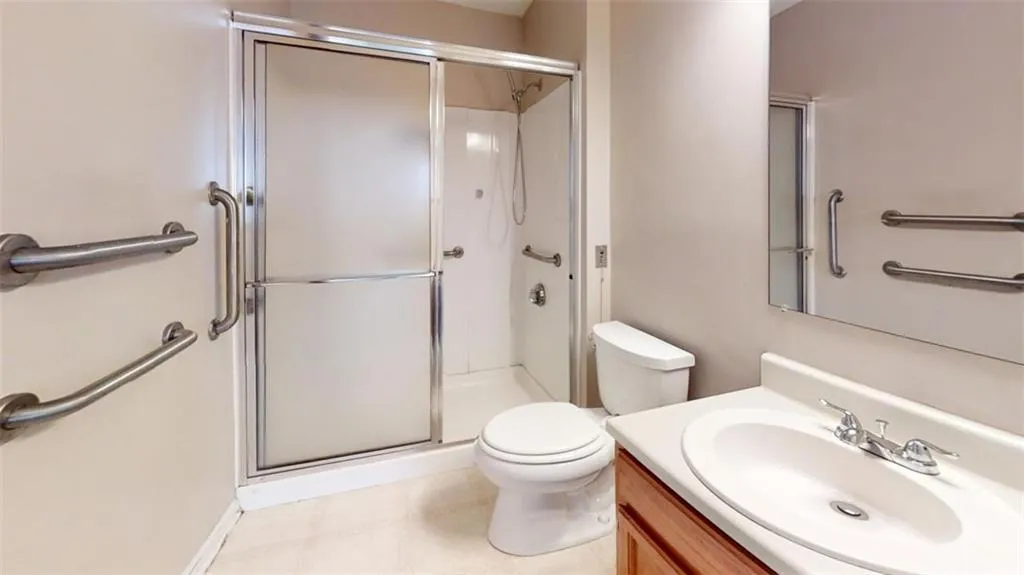 Bathroom with a shower stall, toilet, and vanity