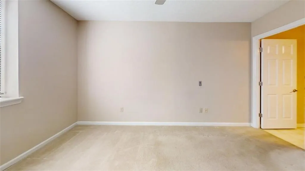 Unfurnished room featuring baseboards, a ceiling fan, and light colored carpet