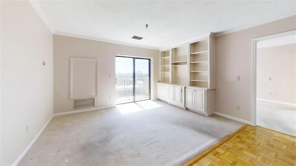 Spare room featuring a textured ceiling, light carpet, visible vents, baseboards, and ornamental molding