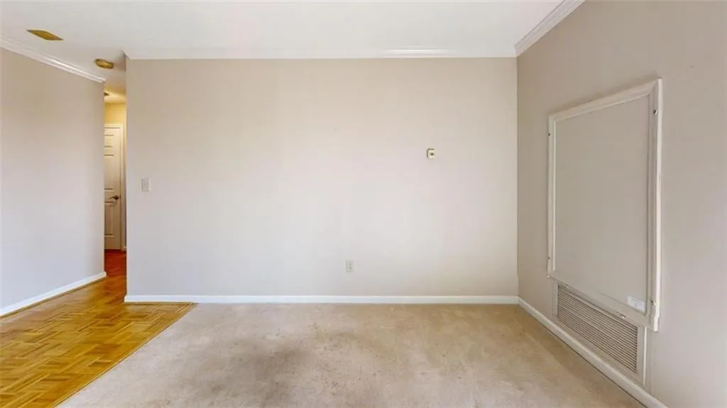 Unfurnished room featuring ornamental molding, visible vents, and baseboards