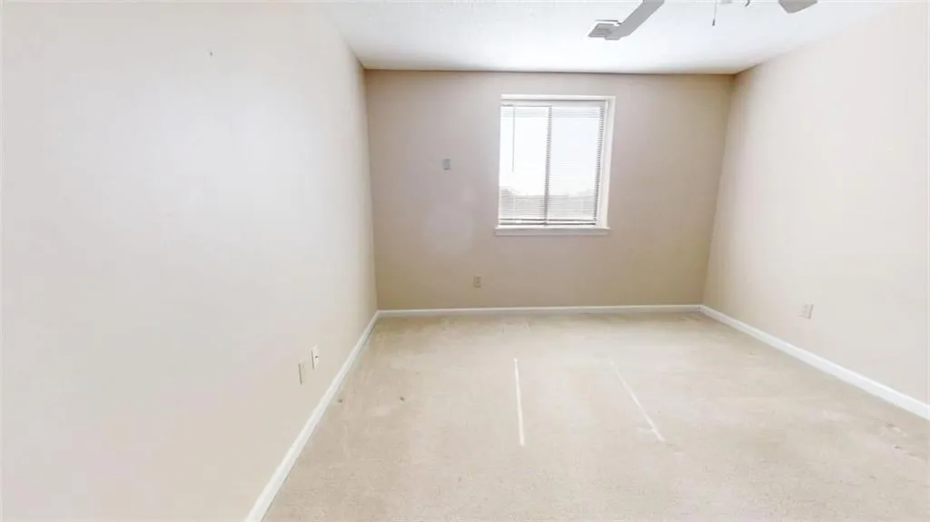 Spare room with light carpet, ceiling fan, and baseboards
