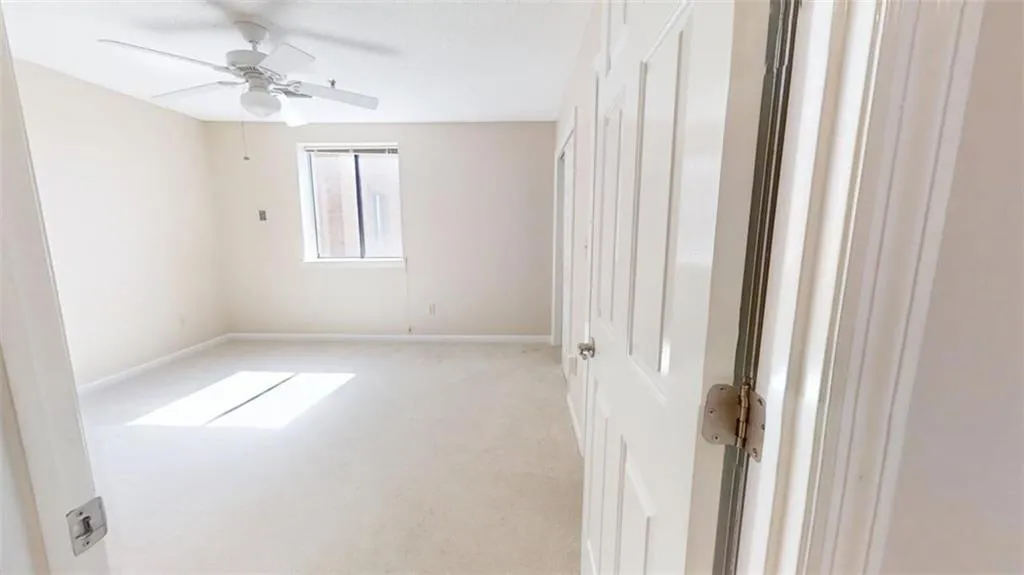 Unfurnished room featuring ceiling fan, baseboards, and light colored carpet