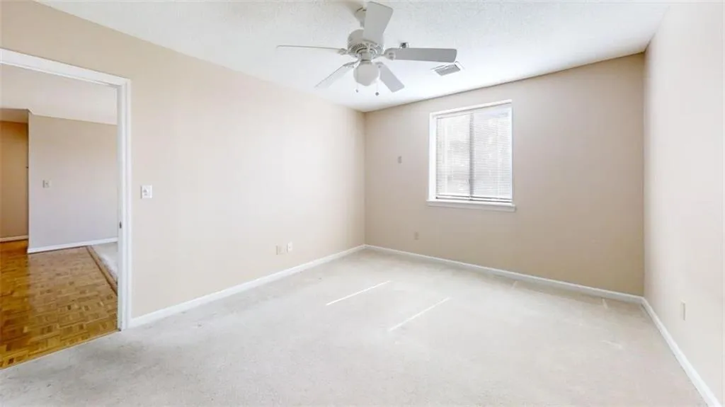 Spare room featuring a textured ceiling, a ceiling fan, visible vents, and baseboards