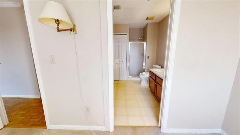 Full bath with baseboards, visible vents, vanity, and toilet