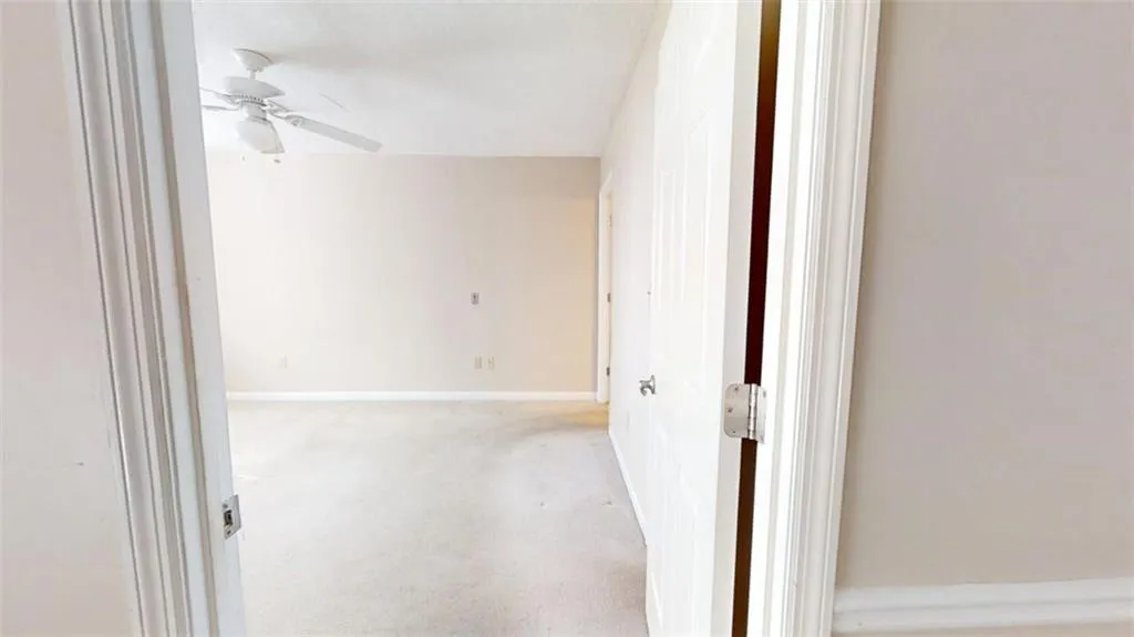 Corridor featuring light carpet and baseboards