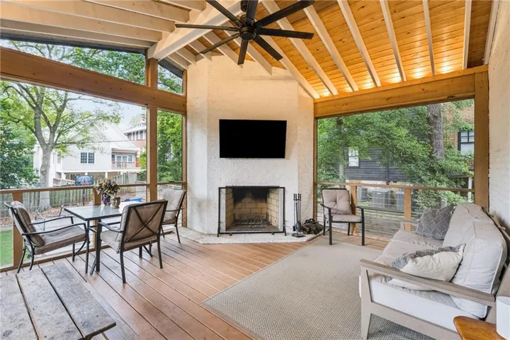 Showstopping screened porch with a fireplace and private backyard views