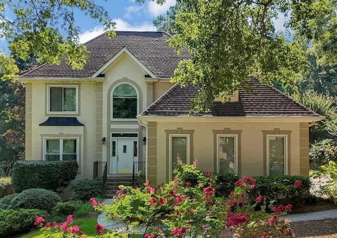 Stucco exterior with a peaked roofline and prominent arched window