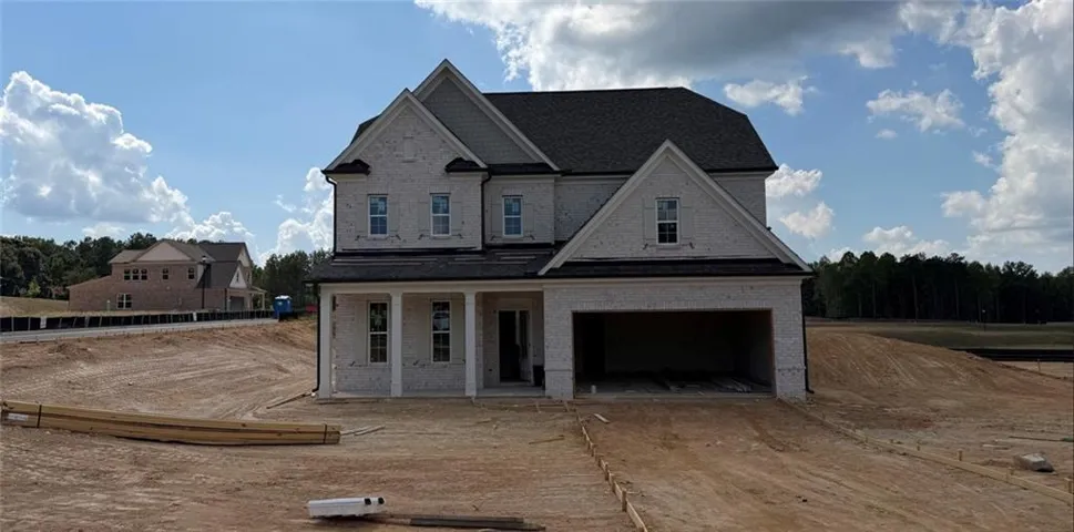 Two-story brick exterior with gabled roof lines, covered front porch, and an integrated garage
