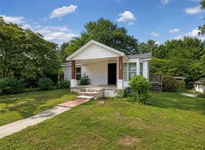 White siding exterior with a covered front porch featuring wood-finish columns