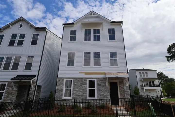 Three-story facade featuring horizontal siding and stone veneer