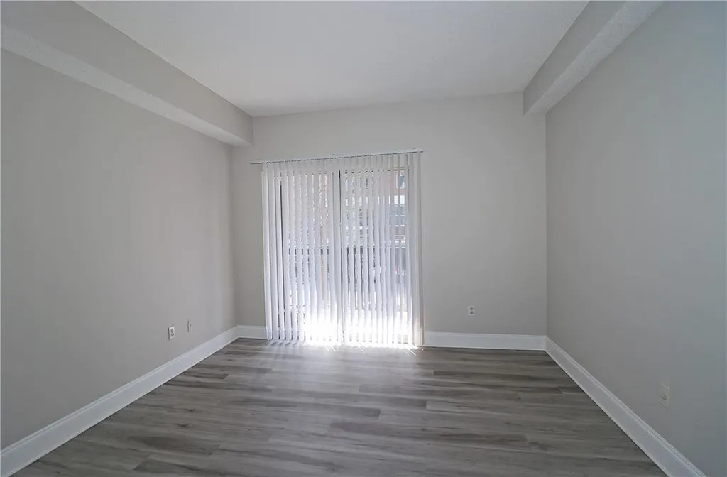 Spare room with baseboards and wood finished floors