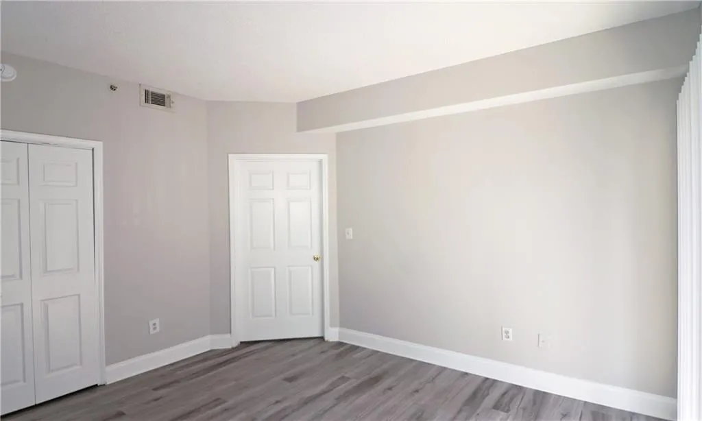 Unfurnished bedroom with visible vents, baseboards, and light wood-style flooring