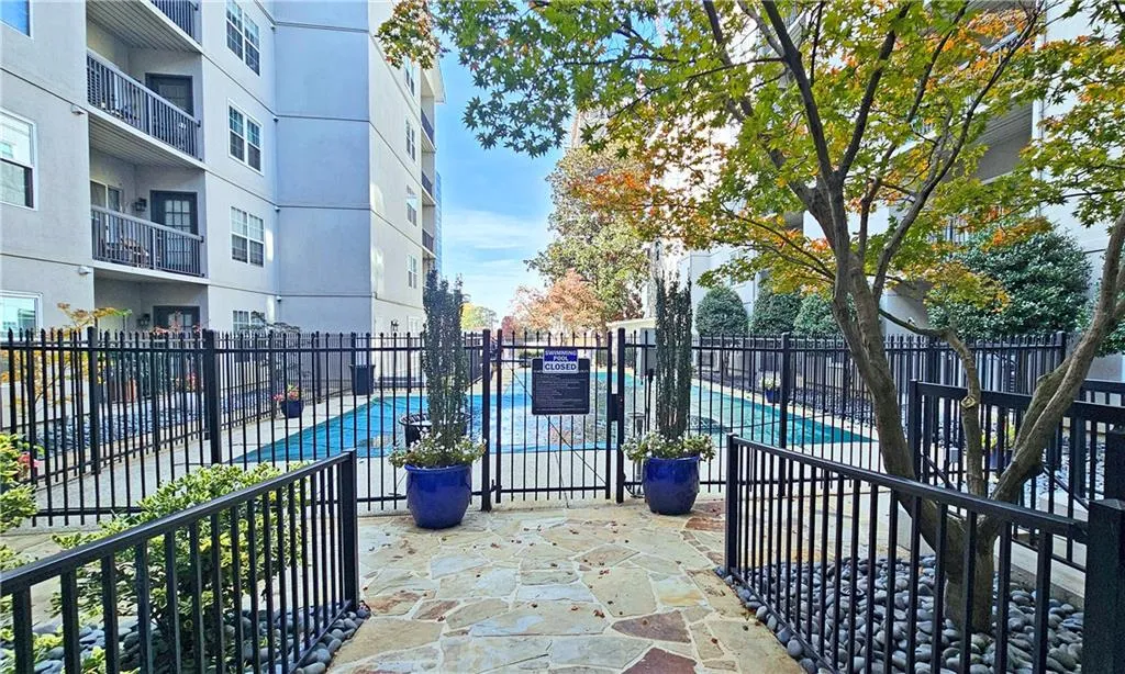 View of patio / terrace with a community pool and fence