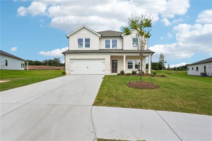 Contemporary two-story residence with a two-car garage, featuring a white brick and vertical siding exterior