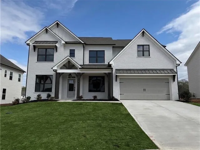 Contemporary white brick facade with black-framed windows, a two-car garage, and a covered front entry with dark wood-look columns