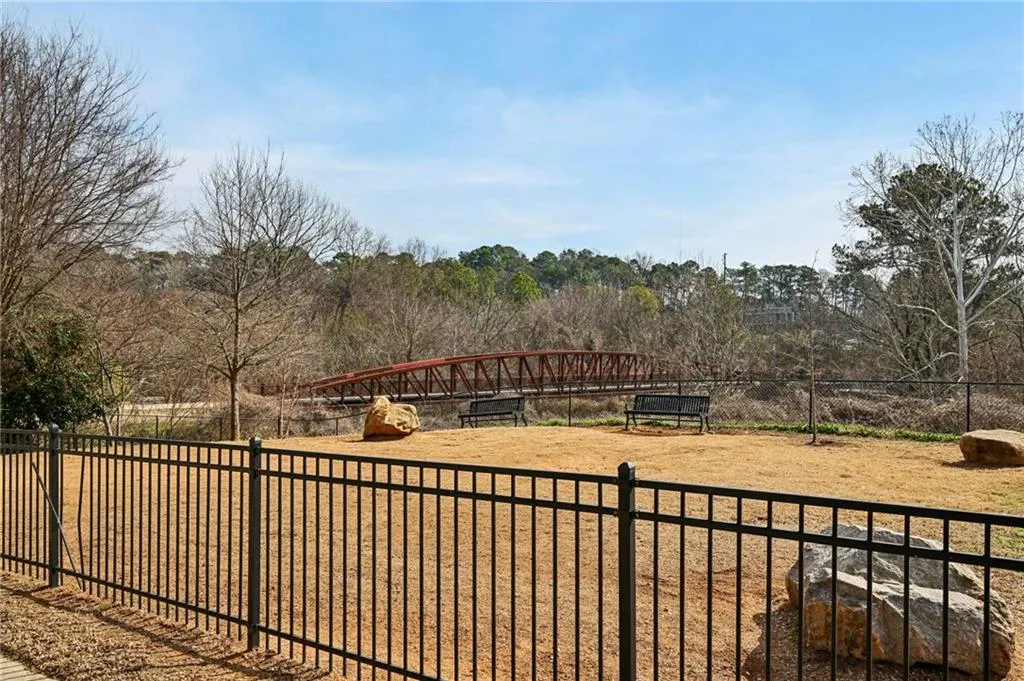 View of yard featuring a dog friendly area and pedestrian bridge.