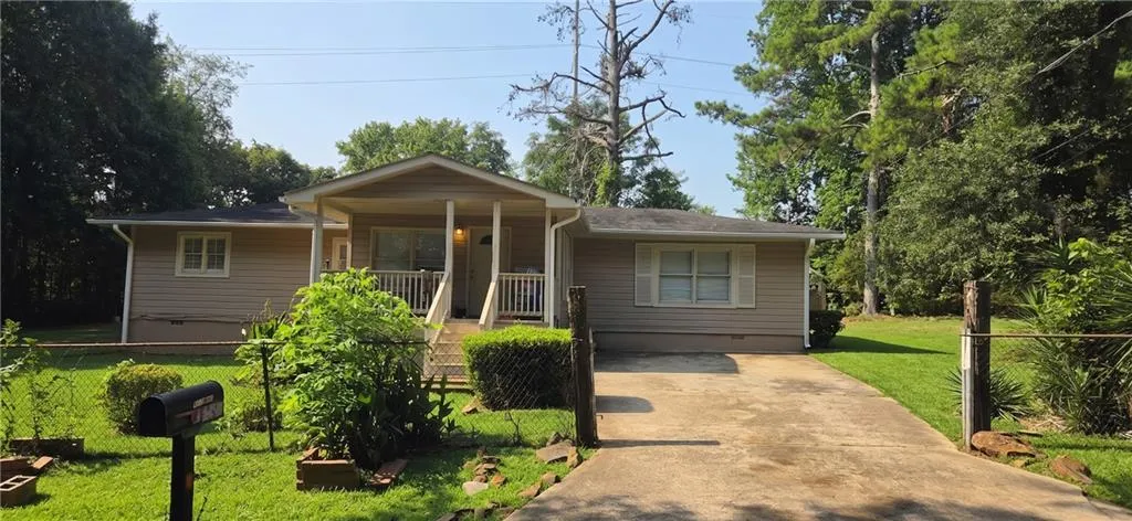 Beige vinyl siding exterior with a covered front porch featuring white railings