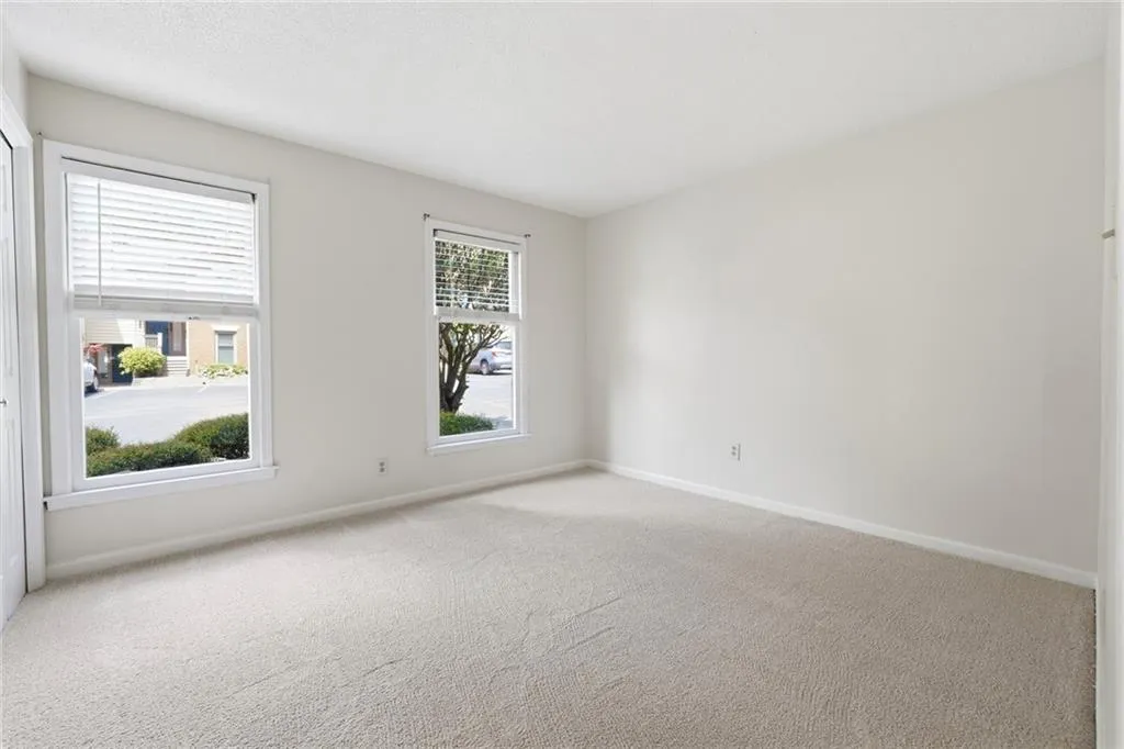 Empty room with light carpet and baseboards