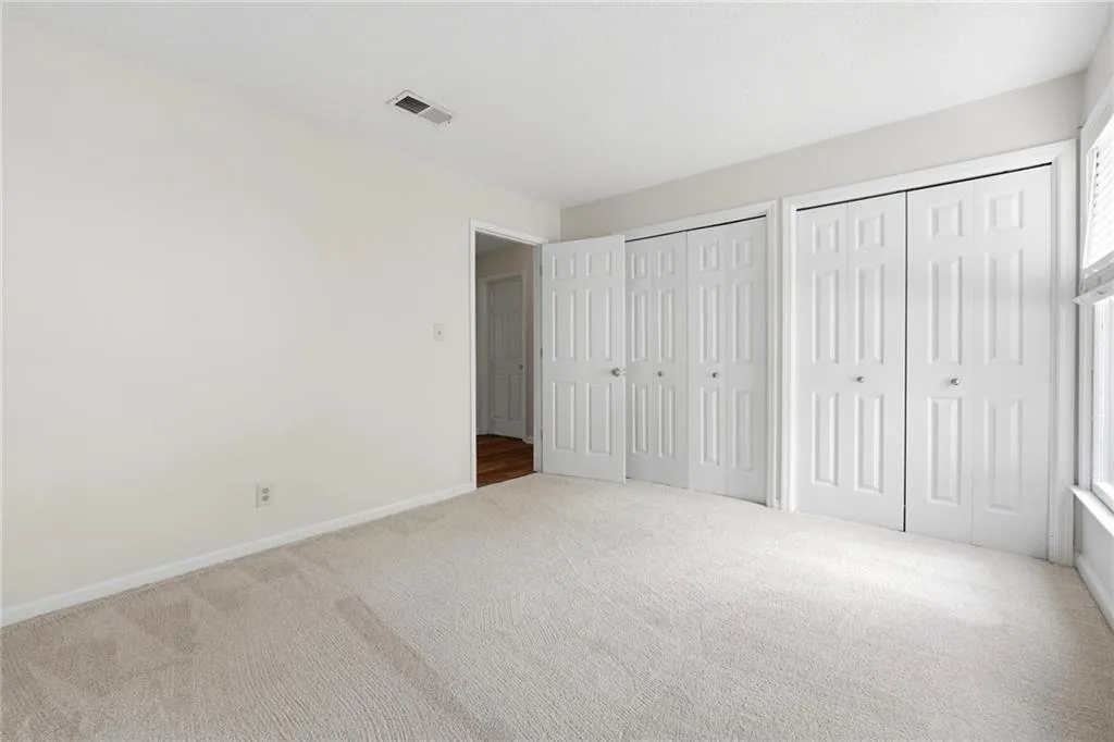 Unfurnished bedroom featuring multiple closets and carpet