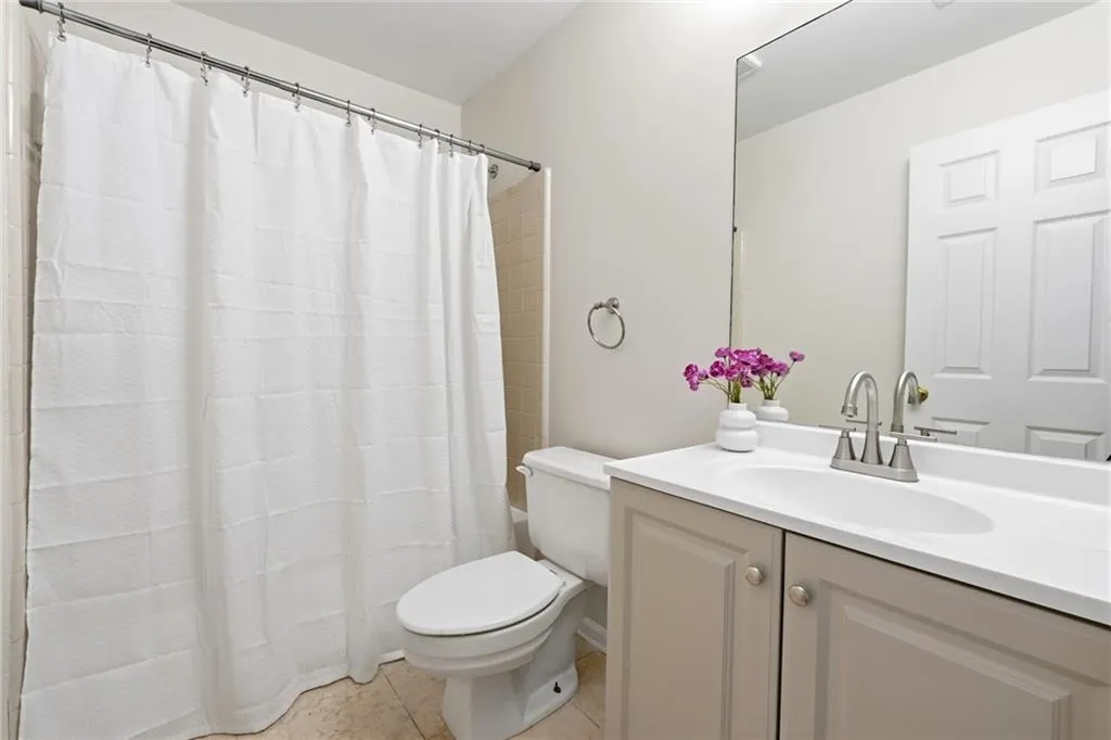 Full bathroom with vanity, a shower with curtain, and light tile patterned floors