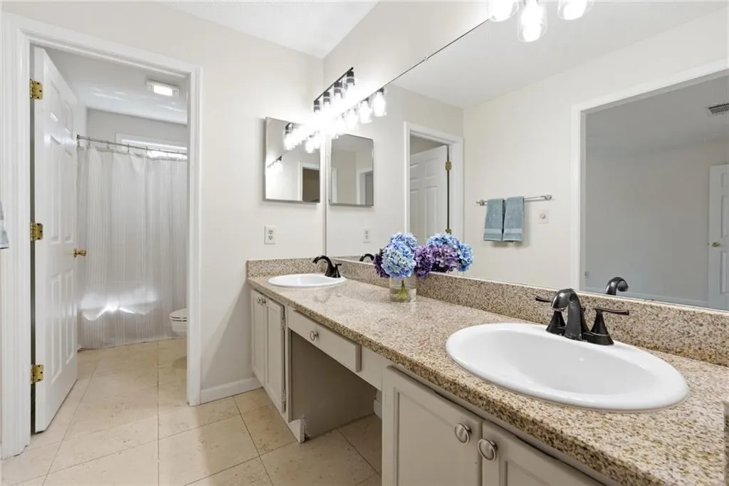 Bathroom featuring double vanity and light tile patterned floors