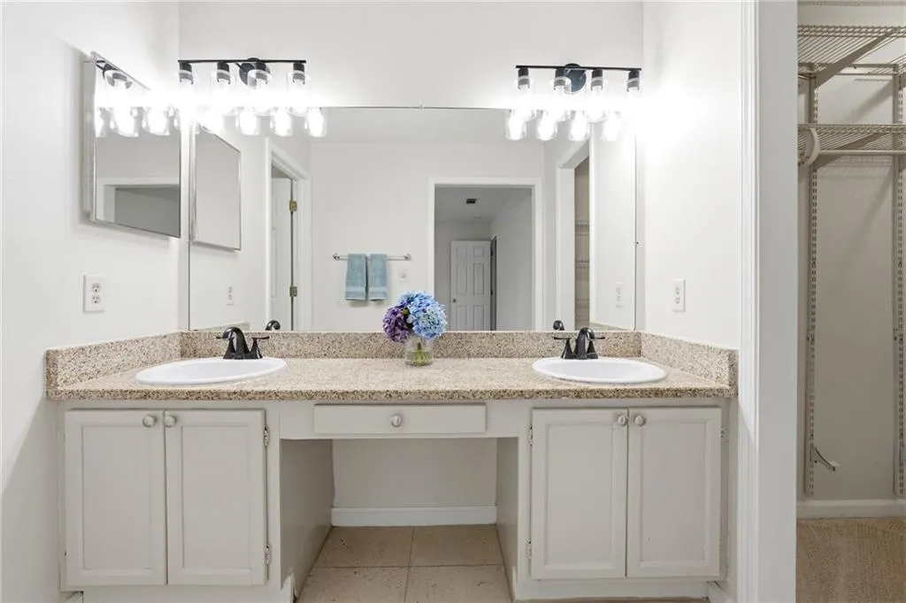 Bathroom with double vanity and light tile patterned floors