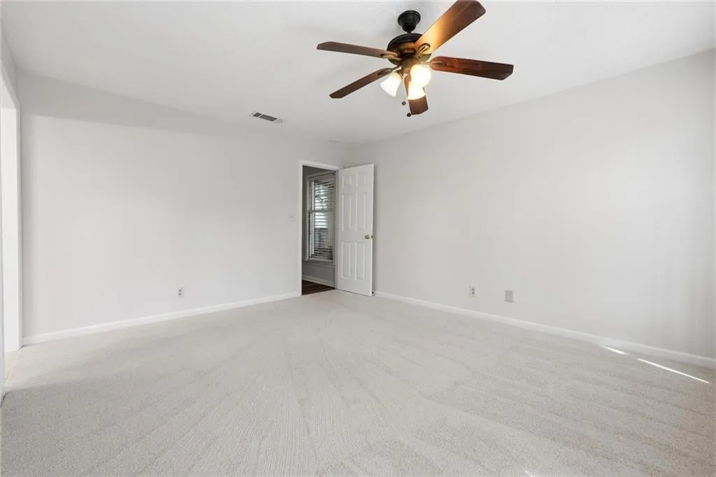 Unfurnished room featuring carpet floors and ceiling fan