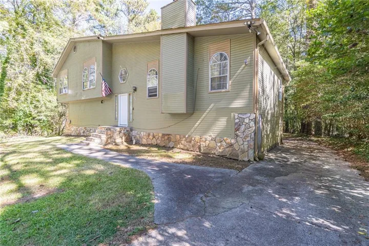 View of front of house with a chimney and a front lawn