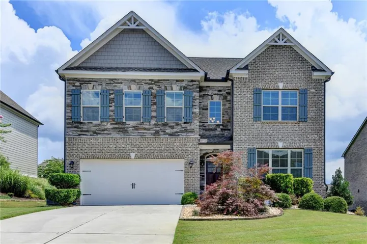 Two-story exterior with a blend of brick and stone facade, complemented by decorative blue window shutters