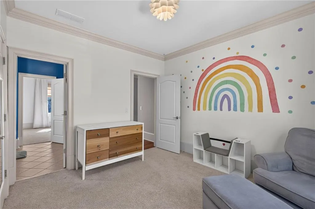 Room featuring crown molding, neutral carpeting, paneled interior doors, and a multi-faceted flush-mount ceiling light fixture