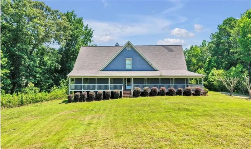 Traditional style residence with blue siding and a dark shingle roof