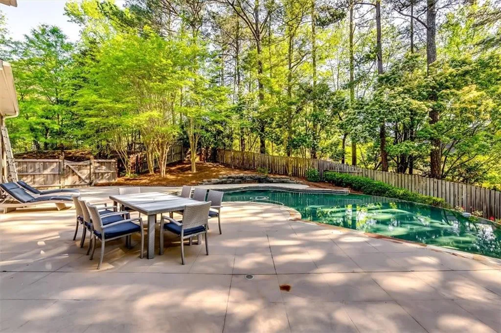 View of swimming pool featuring a fenced backyard, patio surround, and outdoor dining area