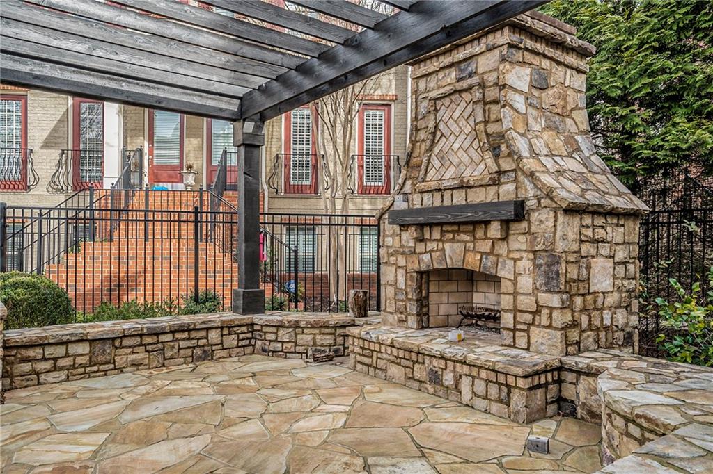 View of patio / terrace featuring a pergola and an outdoor stone fireplace