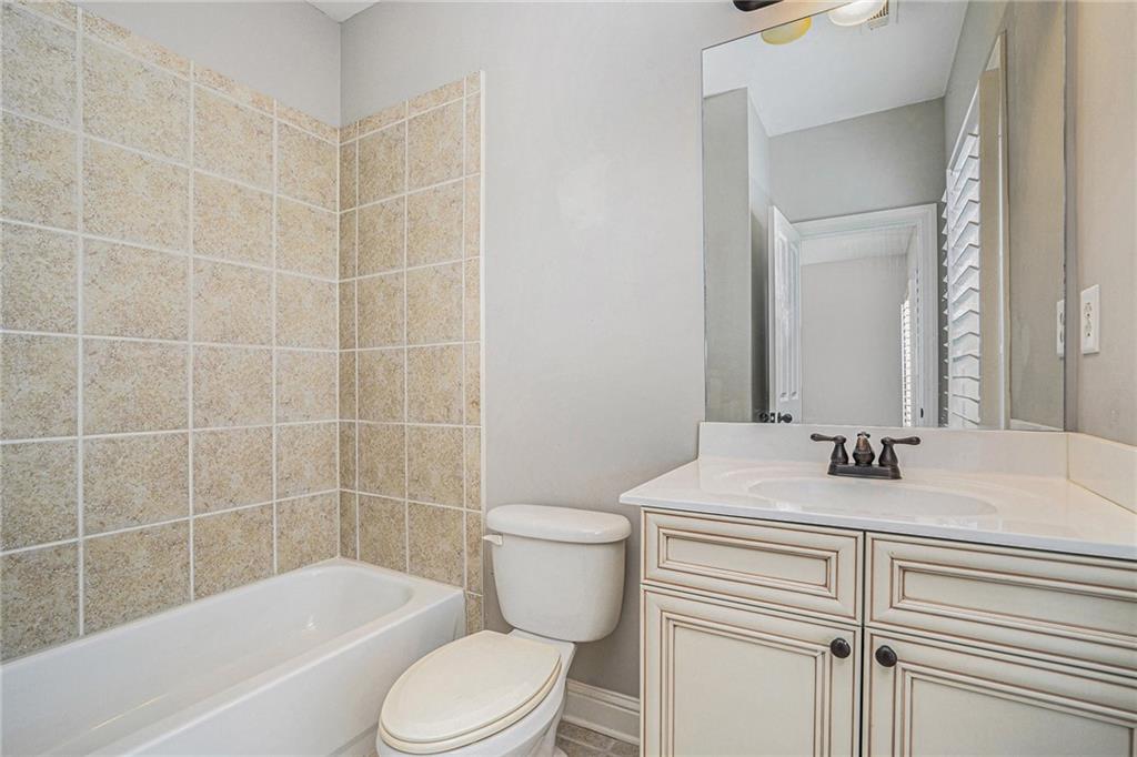 Full bathroom featuring vanity, toilet,  shower combination, and ceiling fan