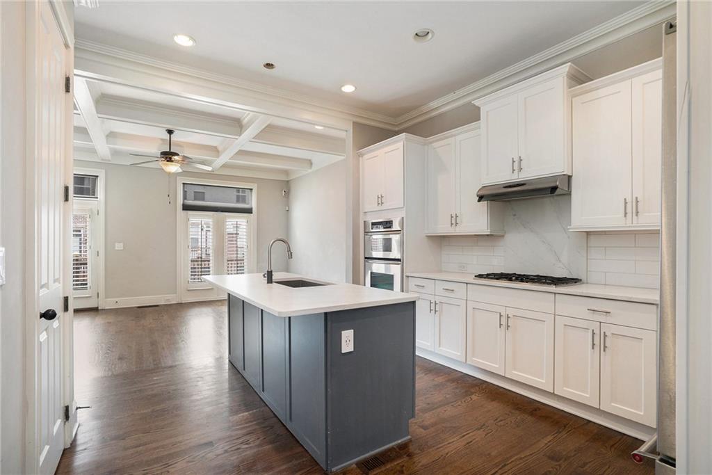 Kitchen with sink, coffered ceiling, white cabinetry, and dark hardwood / wood-style floors
