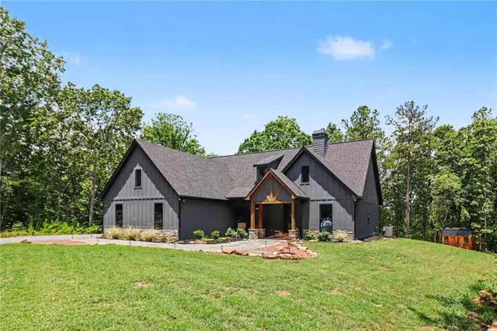 Modern farmhouse exterior featuring dark vertical siding and stone accents