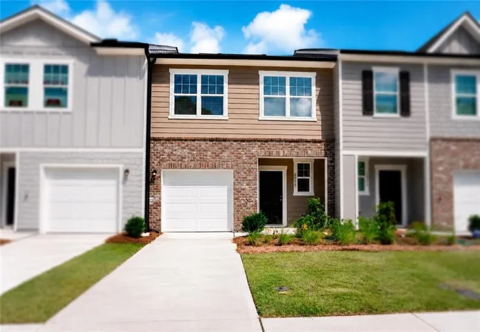 Two-story townhome featuring a brick and siding facade