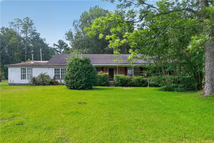 Single-story home featuring a broad front lawn