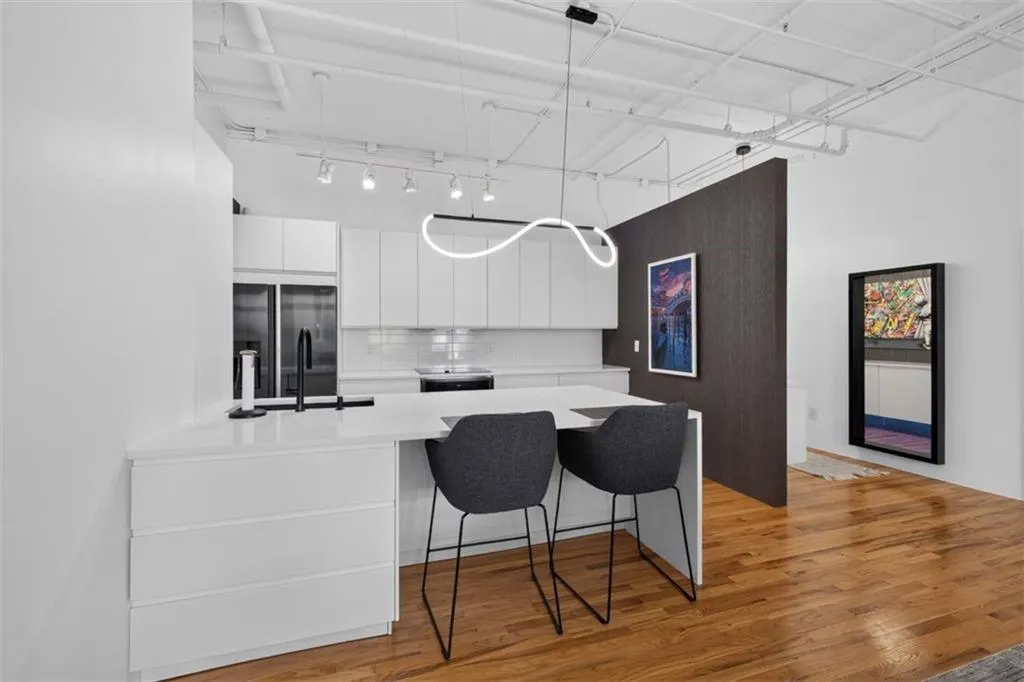 Modern kitchen featuring white cabinetry, a white countertop, subway tile backsplash, and a built-in refrigerator