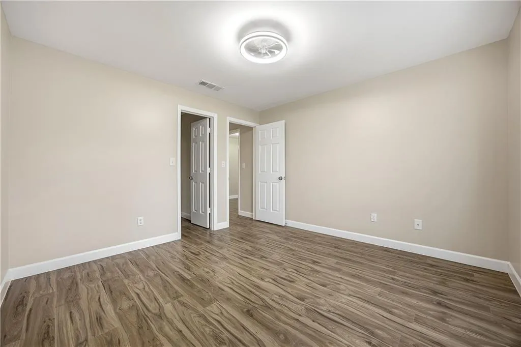 Unfurnished bedroom featuring dark wood finished floors and baseboards