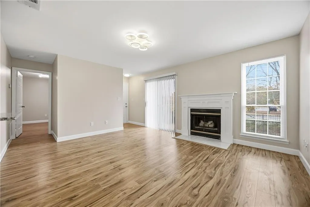 Unfurnished living room featuring a fireplace with flush hearth and light wood-style floors