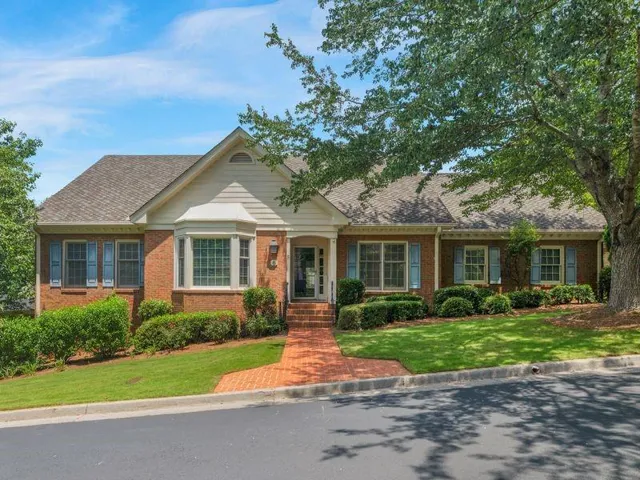 Brick exterior featuring a gabled roofline, bay window, and light blue shutters