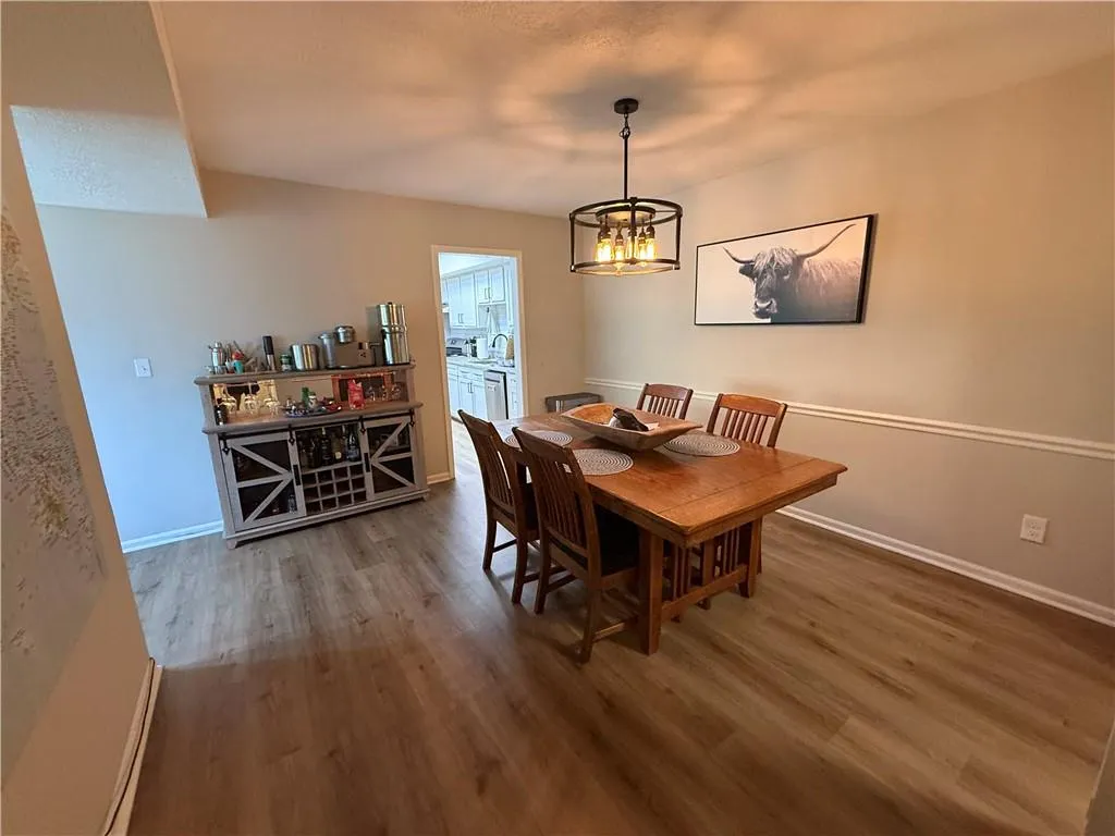 Dining space featuring wood finished floors and a chandelier