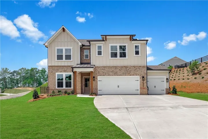Craftsman house featuring concrete driveway, an attached garage, a front yard, brick siding, and board and batten siding