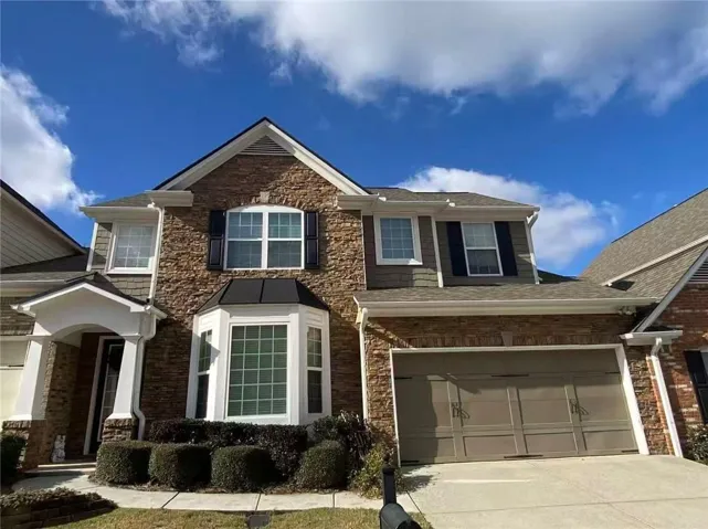 Craftsman house featuring driveway, a garage, stone siding, and roof with shingles