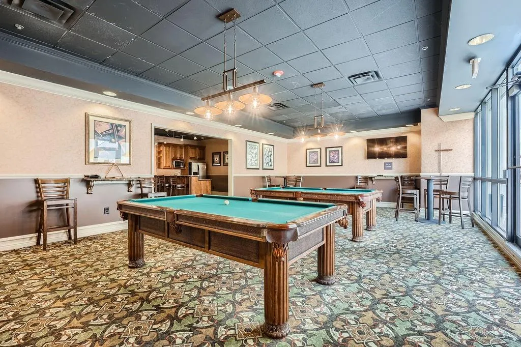 Recreation room featuring ornamental molding, pool table, baseboards, carpet, and a drop ceiling