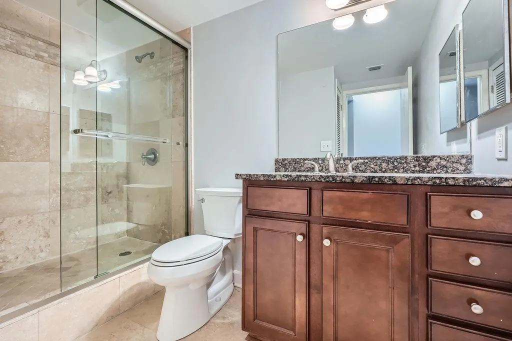 Full bathroom with toilet, a shower stall, vanity, and tile patterned floors